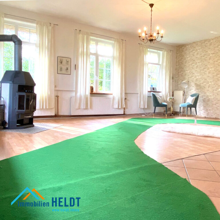 grüner Läufer in großem Raum mit Kaminofen Immobilen HELDT